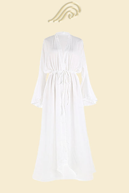 Woman in terracotta gauze maxi dress with tie waist and bell sleeves.