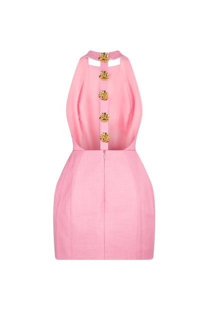 Woman in pink crepe mini dress with gold rose buttons