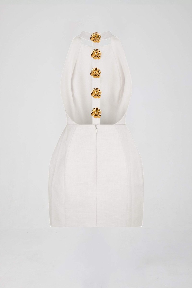 Woman in pink crepe mini dress with gold rose buttons