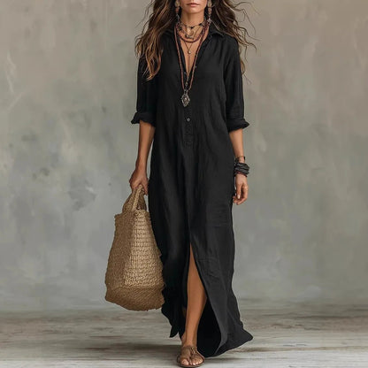 Black - A woman wearing a relaxed-fit white linen maxi sundress with a pointed collar, button placket, and front slit, carrying a woven straw bag.
