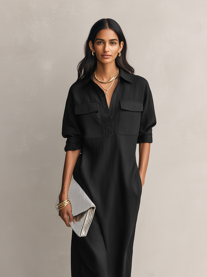 Black - Model wearing a relaxed fit collared midi shirtdress with chest pockets and rolled sleeves, styled with gold jewelry and strappy heels