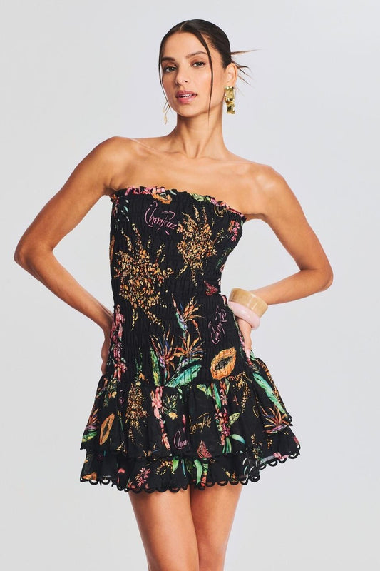 Woman wearing black strapless mini dress with tropical print