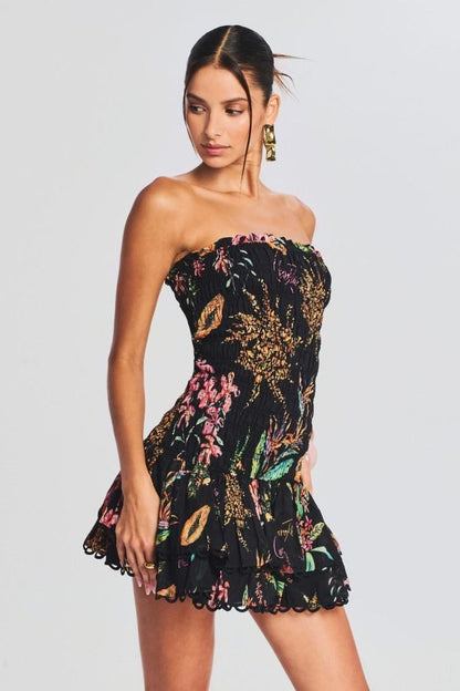 Woman wearing black strapless mini dress with tropical print