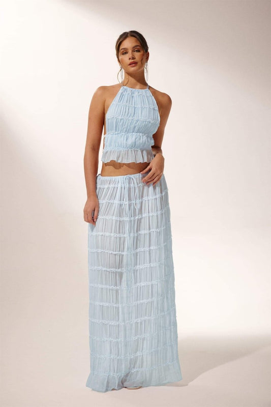 Woman in light blue crinkle gauze halter top and maxi skirt