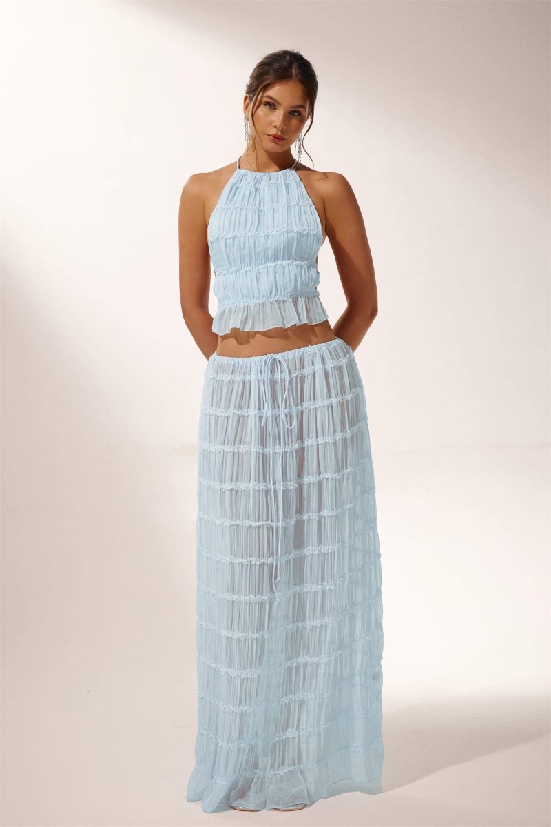 Woman in light blue crinkle gauze halter top and maxi skirt