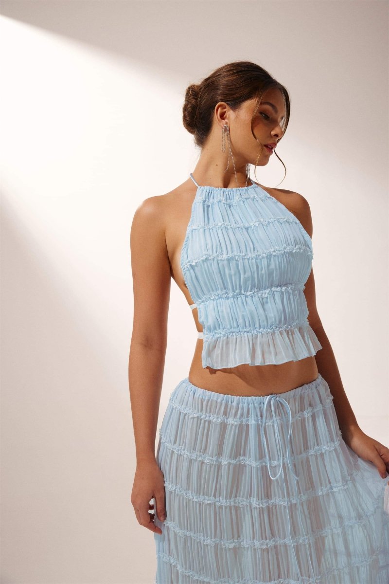Woman in light blue crinkle gauze halter top and maxi skirt