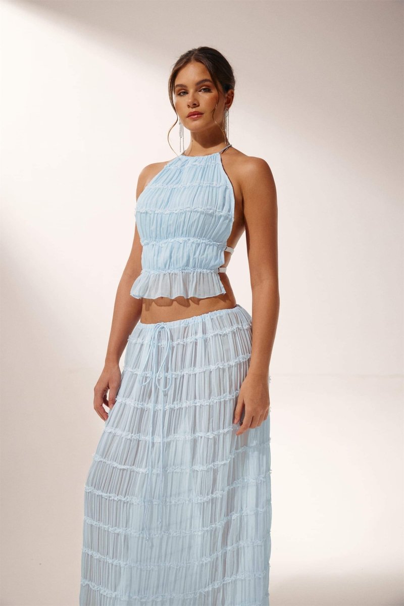 Woman in light blue crinkle gauze halter top and maxi skirt