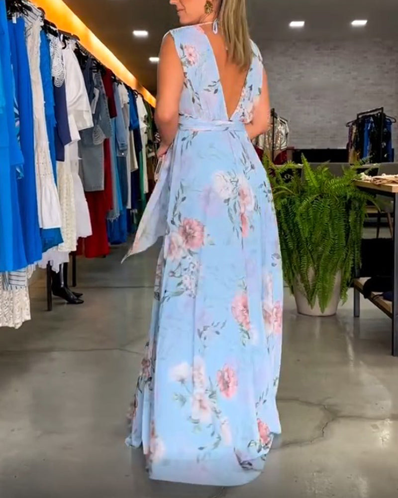 Light Blue - A woman wearing a sleeveless light blue chiffon maxi dress featuring a soft pink rose floral print, a V-neckline, and a defined banded waist.