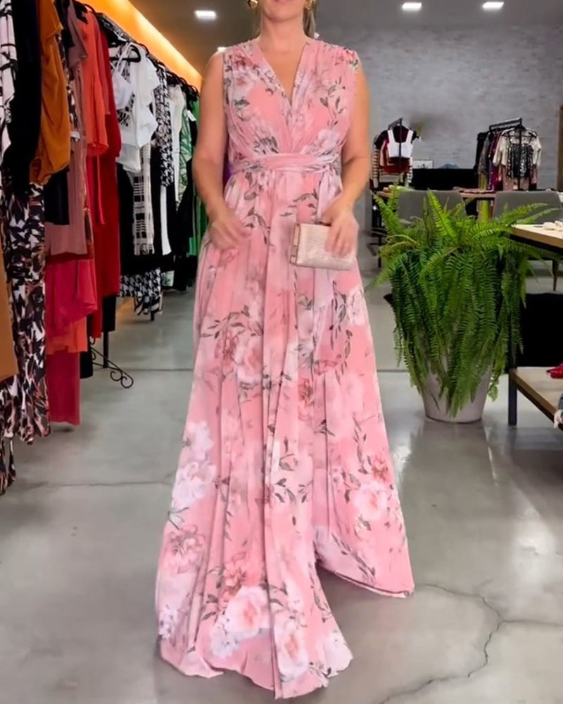 Light Blue - A woman wearing a sleeveless light blue chiffon maxi dress featuring a soft pink rose floral print, a V-neckline, and a defined banded waist.
