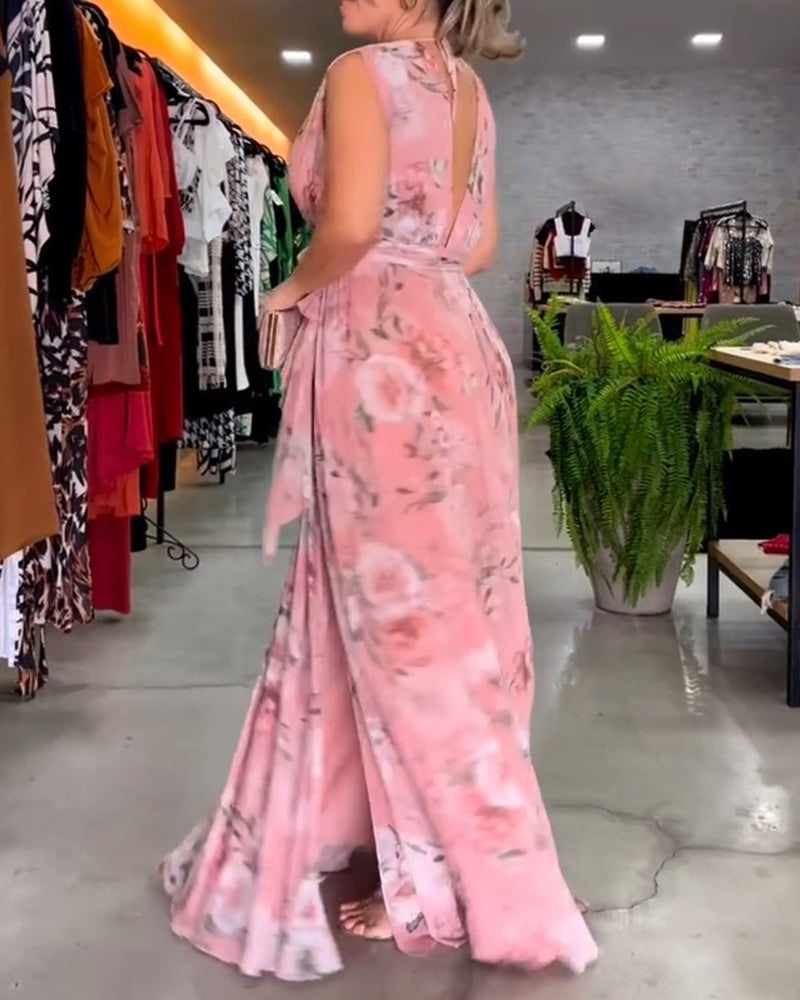Pink - A woman wearing a sleeveless light blue chiffon maxi dress featuring a soft pink rose floral print, a V-neckline, and a defined banded waist.