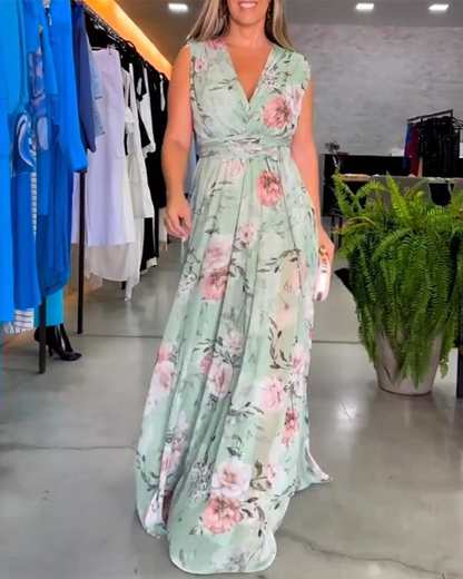 Sage Green - A woman wearing a sleeveless light blue chiffon maxi dress featuring a soft pink rose floral print, a V-neckline, and a defined banded waist.