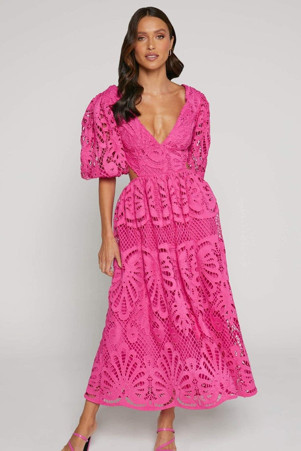 Woman in yellow lace maxi dress with puff sleeves and cut-out waist.