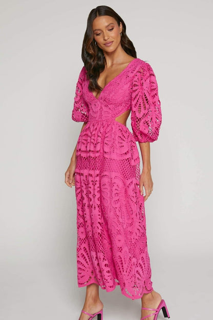 Woman in yellow lace maxi dress with puff sleeves and cut-out waist.