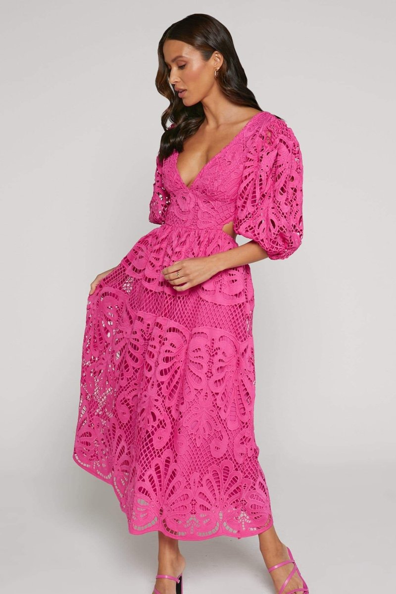Woman in yellow lace maxi dress with puff sleeves and cut-out waist.