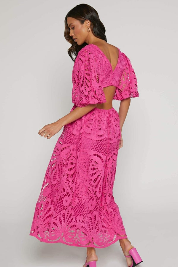 Woman in yellow lace maxi dress with puff sleeves and cut-out waist.