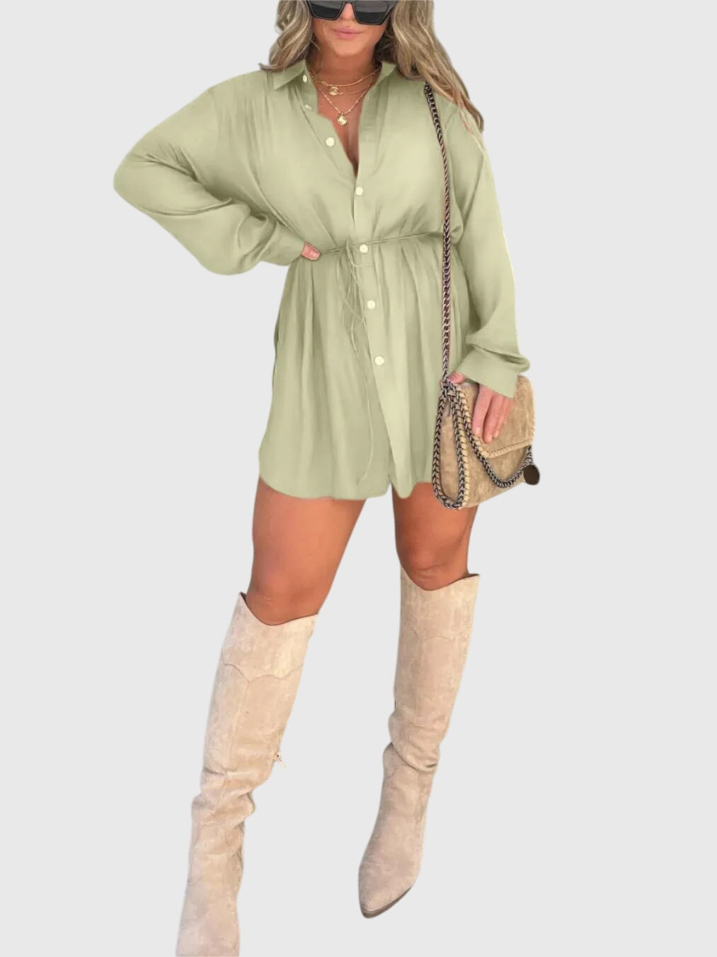 Mint Green - A woman wearing a long-sleeve burgundy satin romper with a button-down front, pointed collar, and cinched waist, styled with knee-high beige boots.