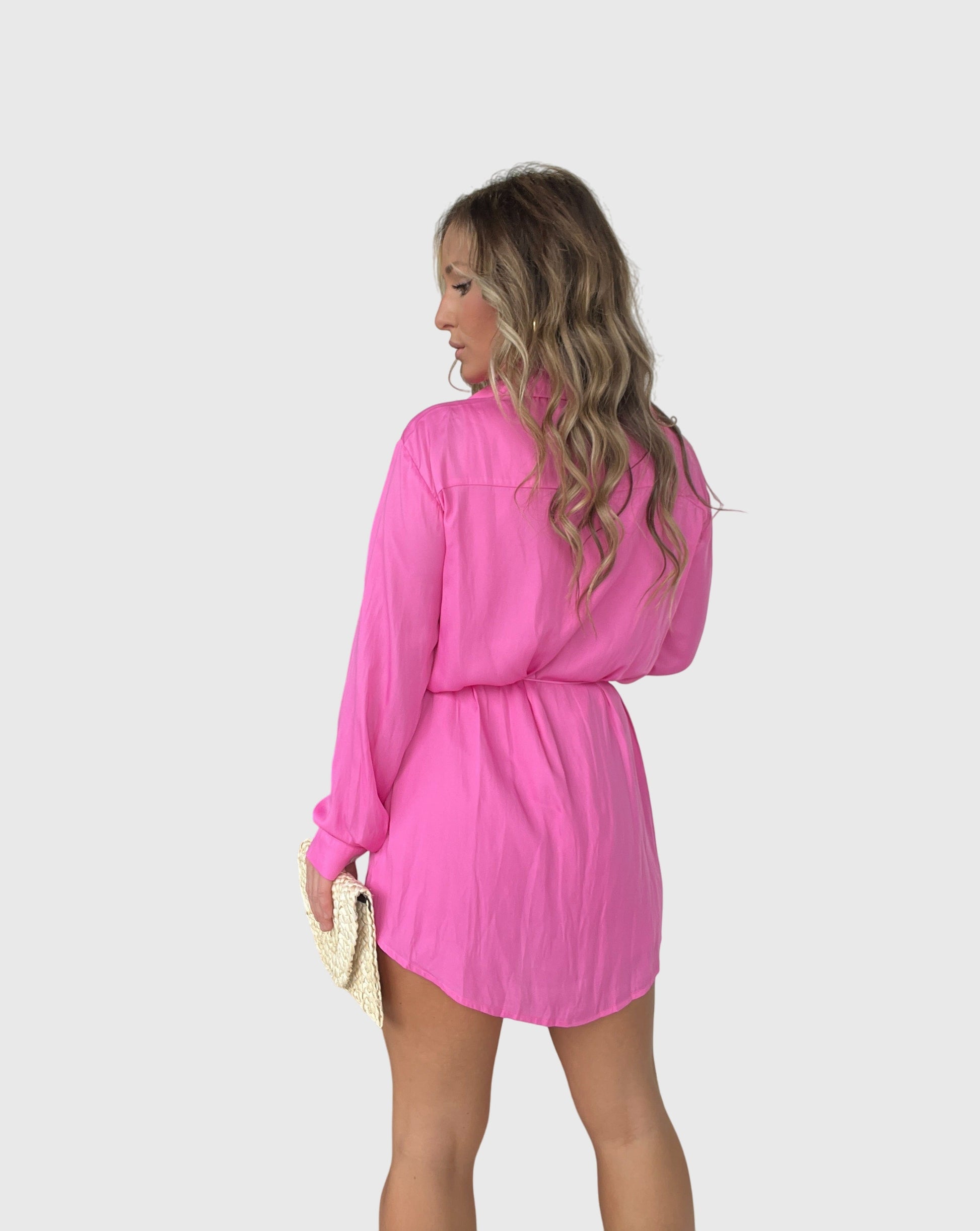 Gray - A woman wearing a long-sleeve burgundy satin romper with a button-down front, pointed collar, and cinched waist, styled with knee-high beige boots.