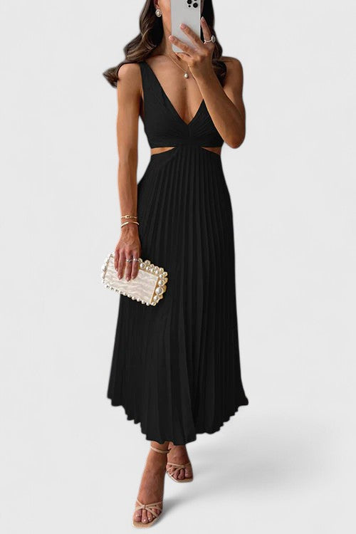 A woman wearing a pale yellow pleated satin midi dress with a plunging V-neckline and side waist cutouts, holding a pearl-embellished clutch.