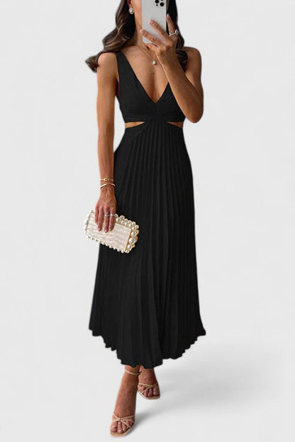 A woman wearing a pale yellow pleated satin midi dress with a plunging V-neckline and side waist cutouts, holding a pearl-embellished clutch.