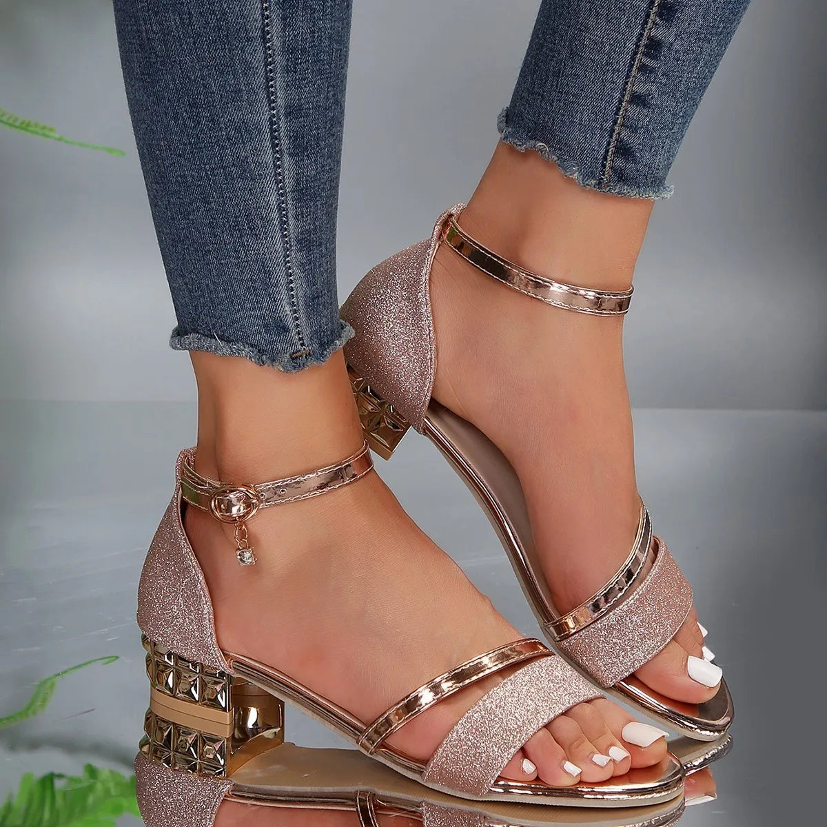 Silver - Women's open-toe block heel sandals featuring a textured shimmer upper, adjustable metallic ankle strap with a small charm, and a distinctive faceted metallic low block heel.