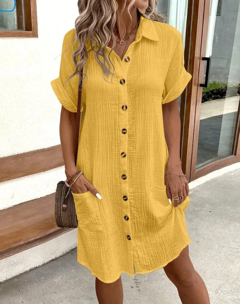 Yellow - Woman wearing a lightweight, textured short-sleeve button-front mini shirt dress with two large front patch pockets.