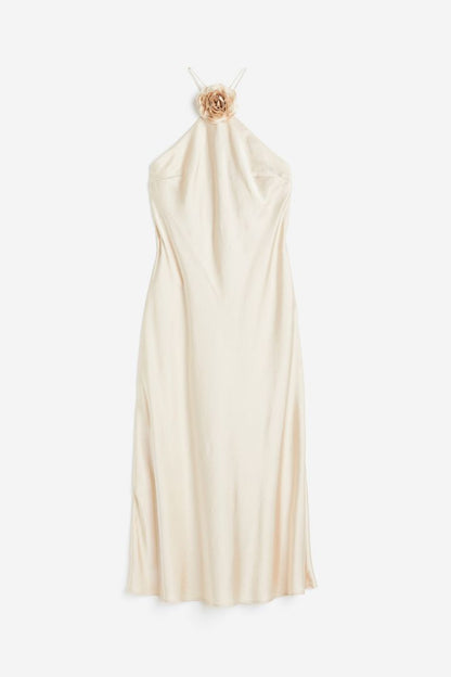 Woman in cream satin halter dress with floral detail