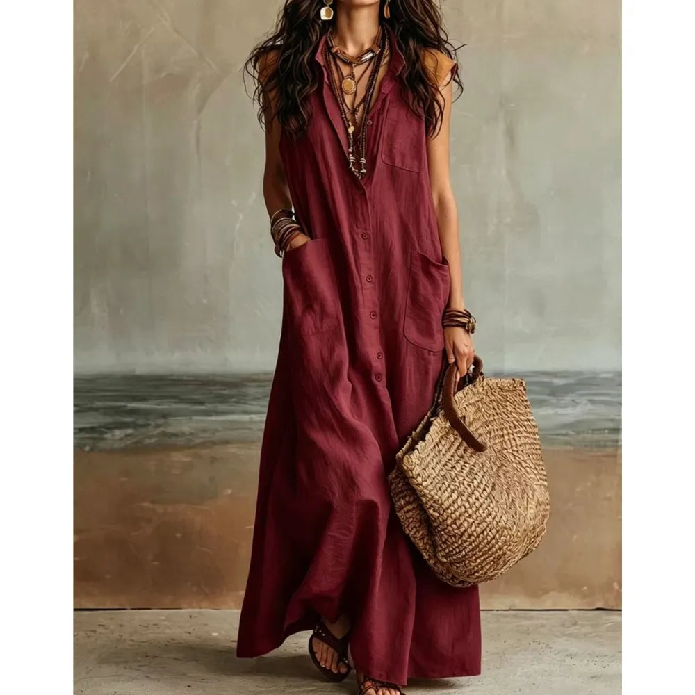 Red - Woman wearing a long, sleeveless linen maxi dress with a collar, button-down front, and large patch pockets, holding a woven tote bag.