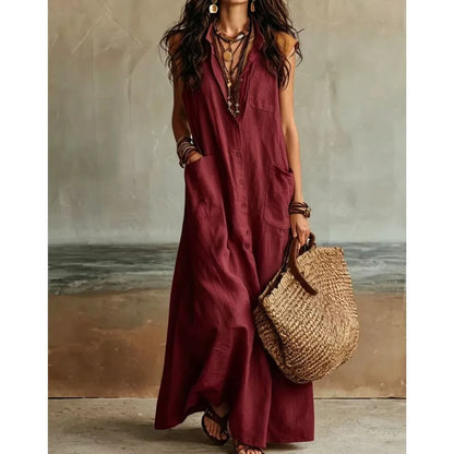 Red - Woman wearing a long, sleeveless linen maxi dress with a collar, button-down front, and large patch pockets, holding a woven tote bag.