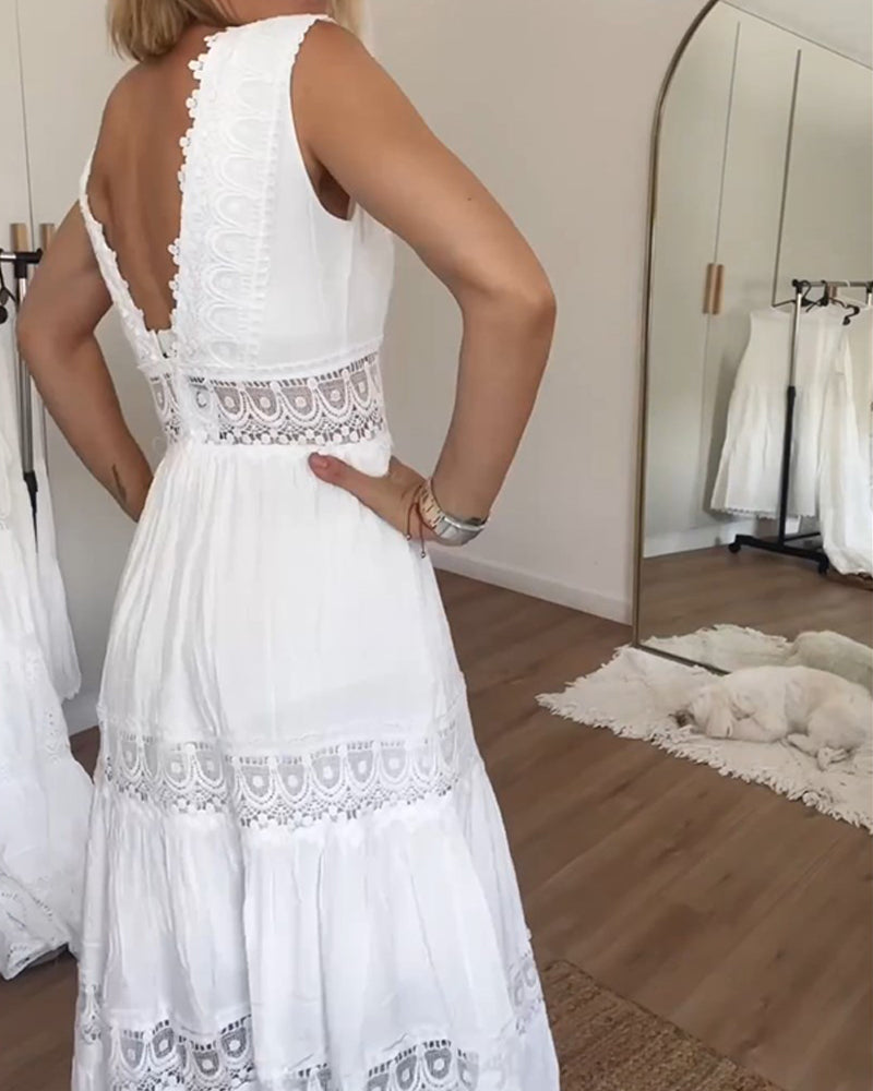A woman wearing a sleeveless white cotton midi dress with a scalloped V-neckline, sheer eyelet lace waist insert, and a tiered skirt with lace paneling.