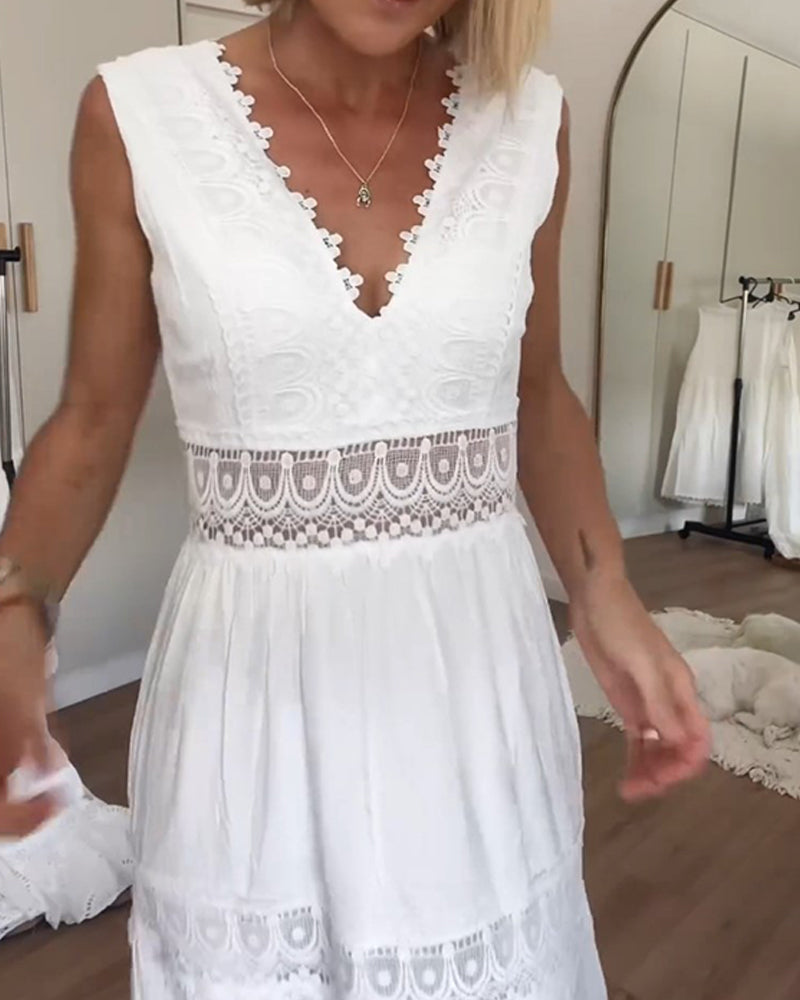 A woman wearing a sleeveless white cotton midi dress with a scalloped V-neckline, sheer eyelet lace waist insert, and a tiered skirt with lace paneling.
