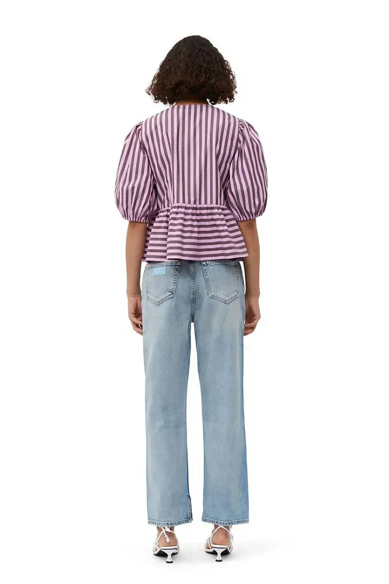 Woman in pink and brown striped blouse and khaki shorts holding sunglasses