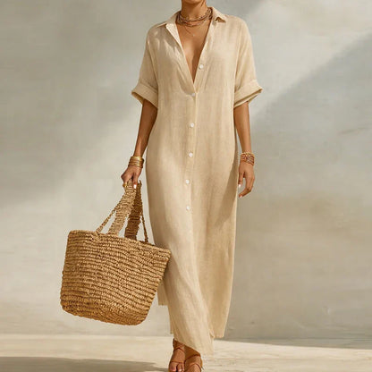 Biege - Woman walking outdoors wearing a long, striped, short-sleeve button-front maxi dress and carrying a woven straw tote bag.