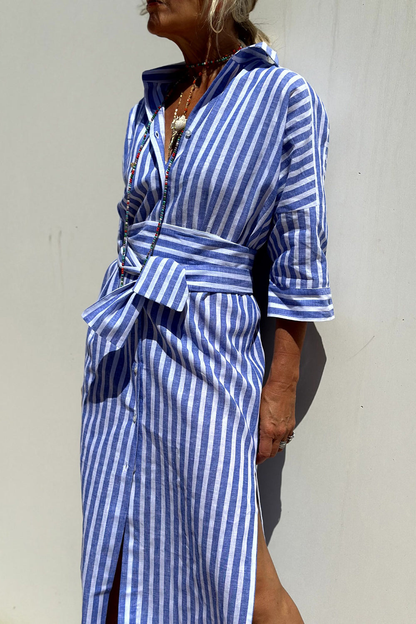 Pink - Woman walking outdoors wearing a striped poplin button-front midi dress with a collar and 3/4 sleeves, carrying a woven straw tote bag.