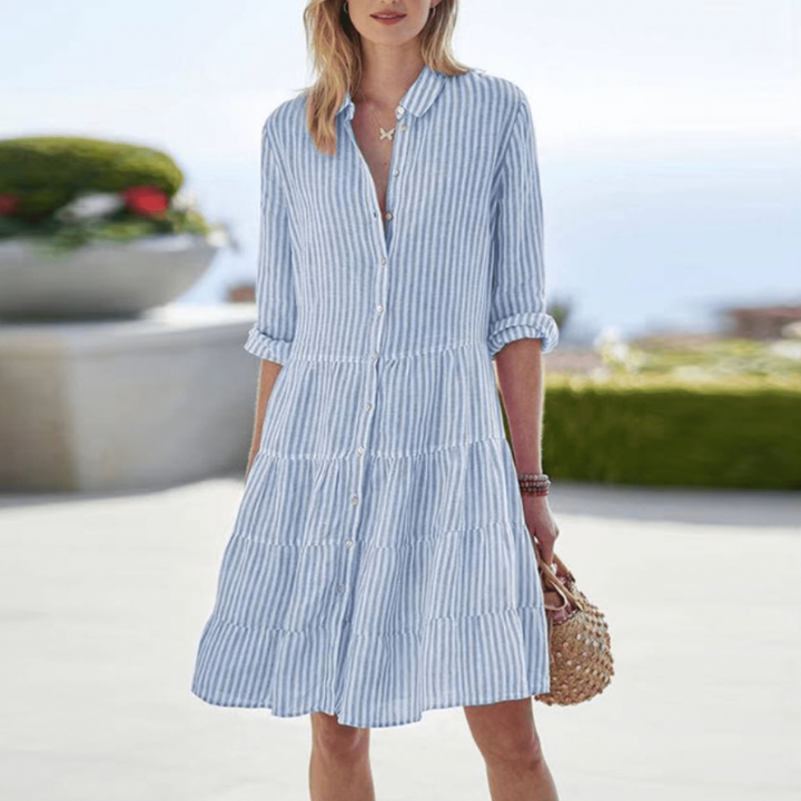Light Blue - Woman walking outdoors wearing a striped long sleeve button down tiered midi dress