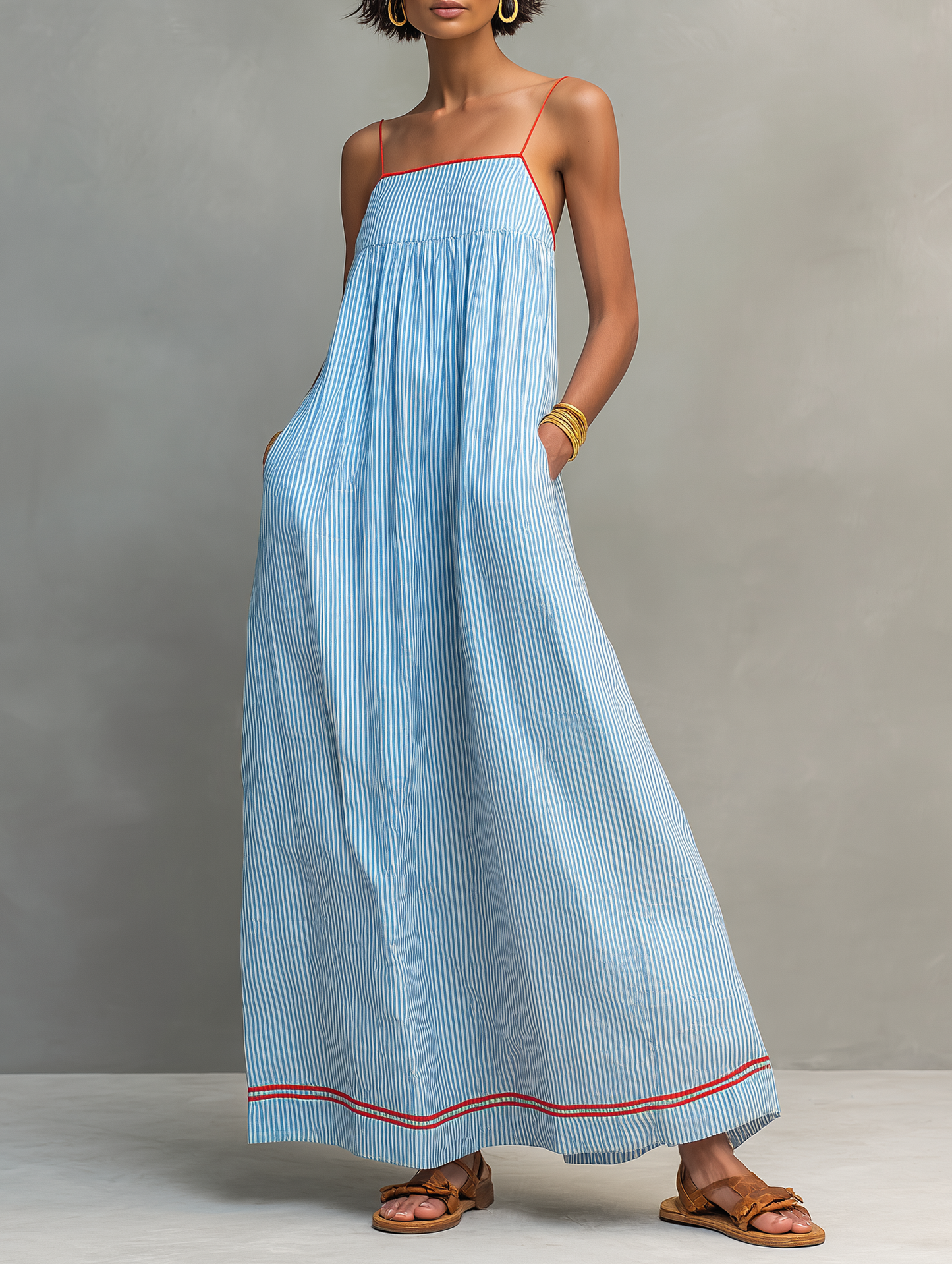 Blue - Model wearing a relaxed fit striped maxi dress with thin contrast straps and side pockets.