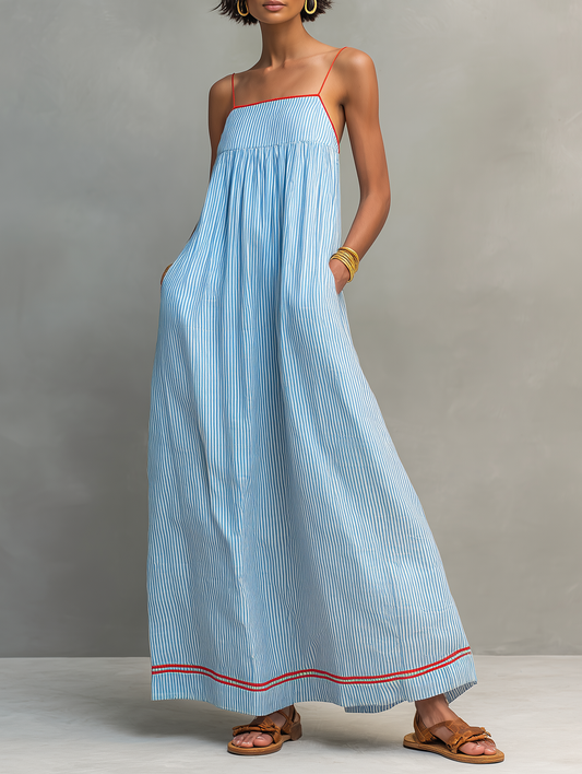 Blue - Model wearing a relaxed fit striped maxi dress with thin contrast straps and side pockets.