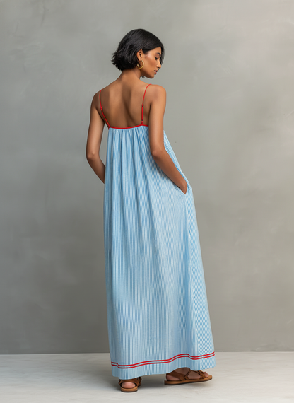 Blue - Model wearing a relaxed fit striped maxi dress with thin contrast straps and side pockets.