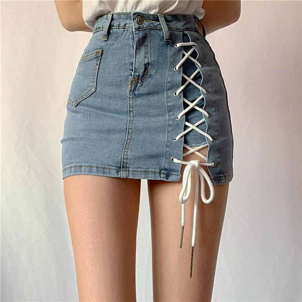 Woman wearing a light blue denim mini skirt with white lace-up side detail.