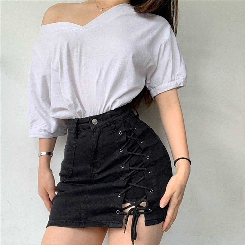 Woman wearing a light blue denim mini skirt with white lace-up side detail.