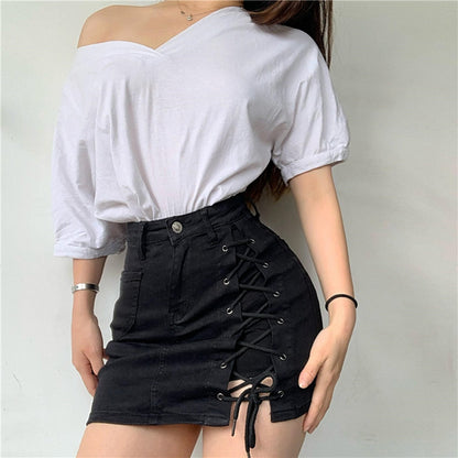 Woman wearing a light blue denim mini skirt with white lace-up side detail.
