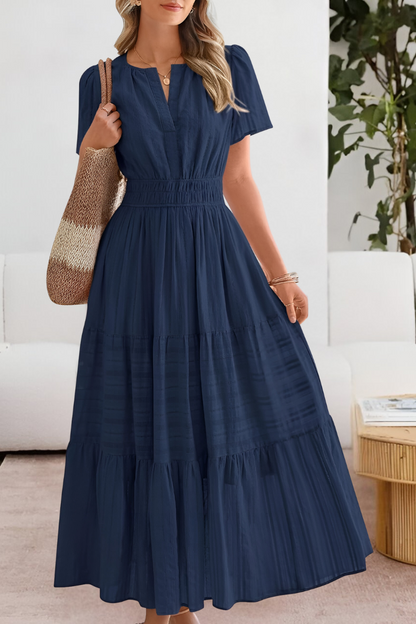 Navy Blue - A woman wearing a yellow textured cotton maxi sundress featuring a smocked waist, flutter sleeves, and a tiered skirt, carrying a woven straw tote bag.