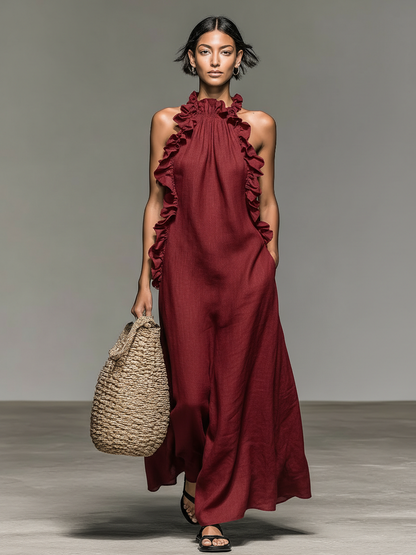 Red - Model walking in a sleeveless, textured maxi dress with a ruffled halter neckline, carrying a woven straw bag.