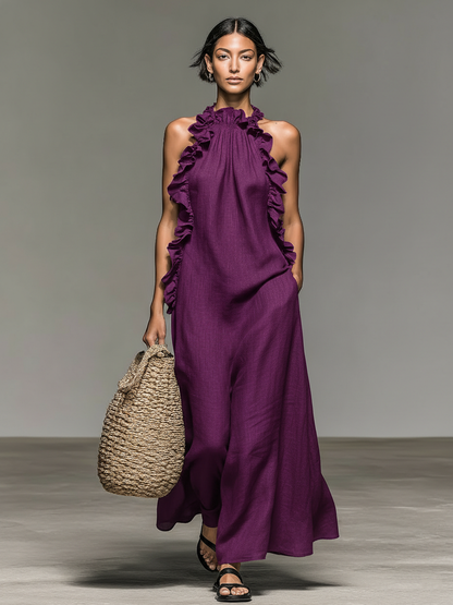 Purple - Model walking in a sleeveless, textured maxi dress with a ruffled halter neckline, carrying a woven straw bag.