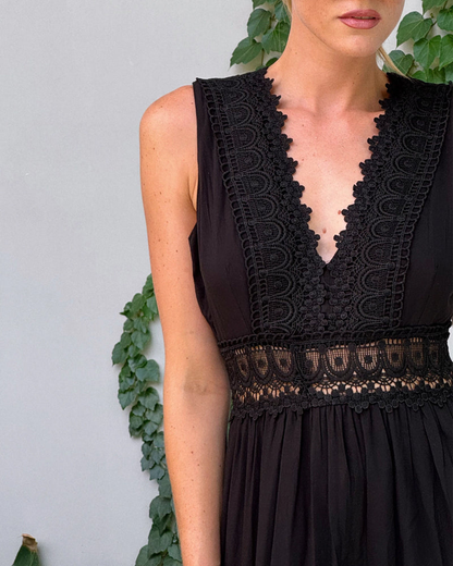 Black - Woman wearing a sleeveless V-neck tiered maxi sundress featuring intricate crochet waist paneling and trim details.