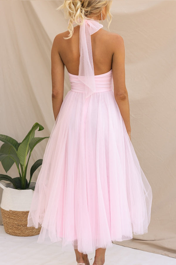 Pink - Woman wearing a sleeveless tulle midi dress with a sheer halter neckline and structured corset bodice