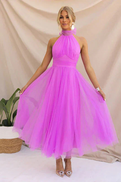 Fuschia - Woman wearing a sleeveless tulle midi dress with a sheer halter neckline and structured corset bodice
