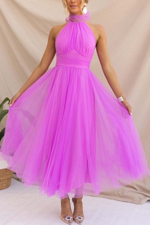Fuschia - Woman wearing a sleeveless tulle midi dress with a sheer halter neckline and structured corset bodice