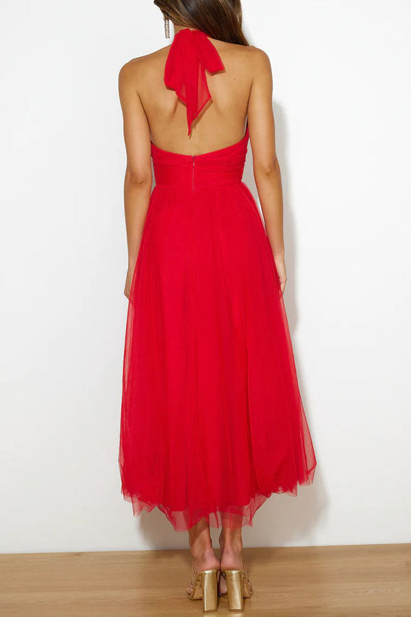 Red - Woman wearing a sleeveless tulle midi dress with a sheer halter neckline and structured corset bodice