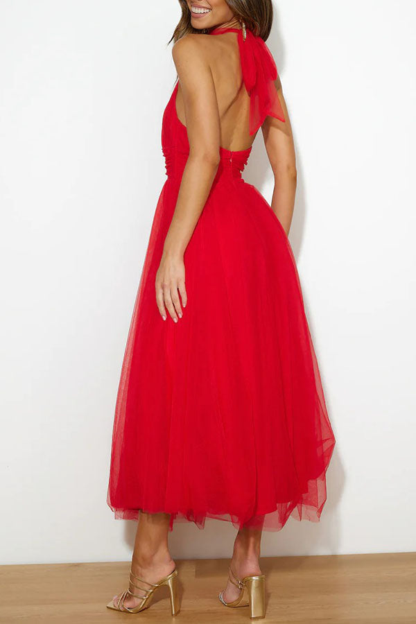 Red - Woman wearing a sleeveless tulle midi dress with a sheer halter neckline and structured corset bodice