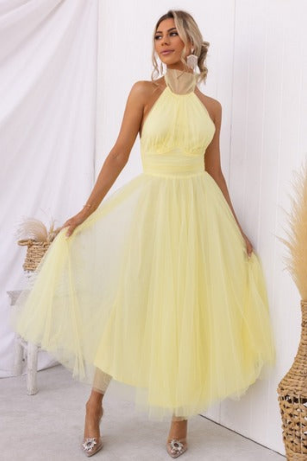Light Yellow - Woman wearing a sleeveless tulle midi dress with a sheer halter neckline and structured corset bodice